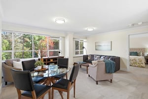 Bright living and dining area with large windows at Judson Park, a HumanGood community.