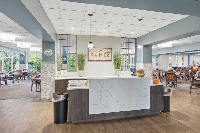 The entrance area of Judson Park’s dining room, featuring modern design, warm lighting, and welcoming shared seating.
