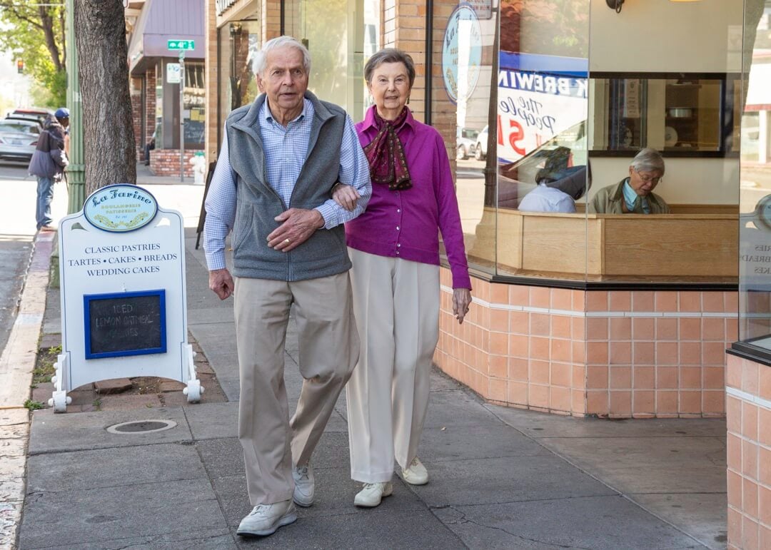 couple walking in front of french bakery