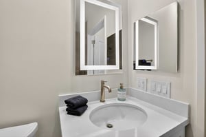 Bathroom vanity with lighted mirror in an assisted living residence at The Terraces of Los Gatos
