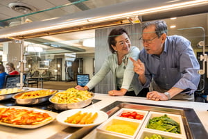 Residents choosing meal options together at a dining station at Judson Park, a HumanGood community.