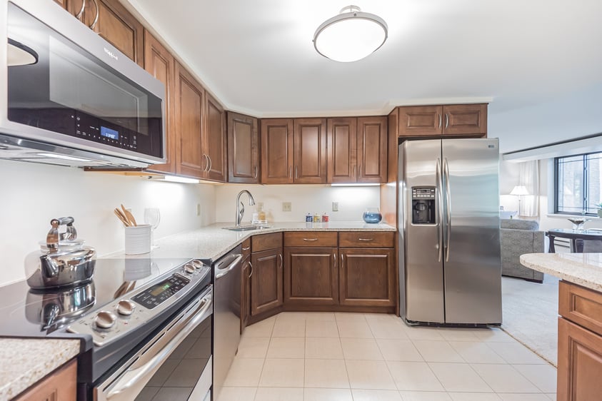 Kitchen with dark wood cabinets and stainless steel appliances in a home at Rydal Park & Waters