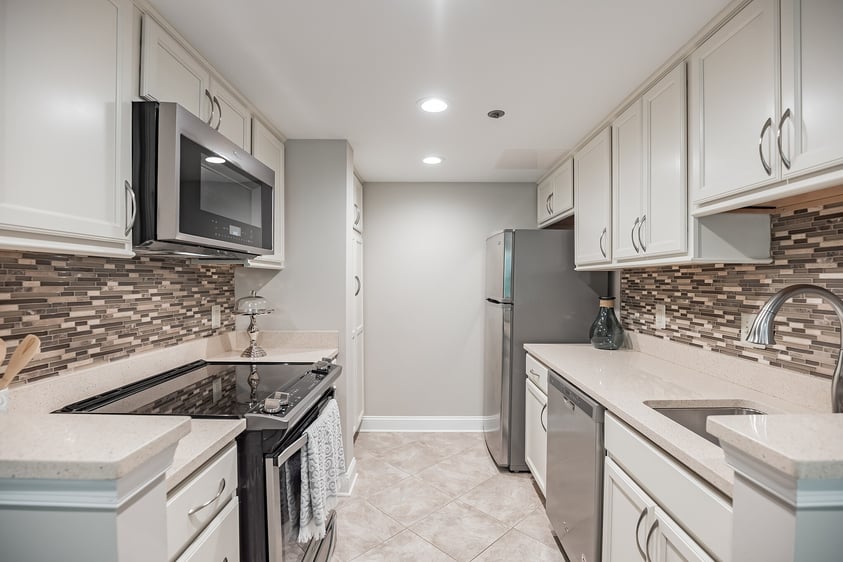 White kitchen with stainless steel appliances in an apartment at Rydal Park & Waters