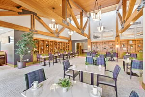 Dining area with wooden beams, marble-topped tables, and decorative bookshelves