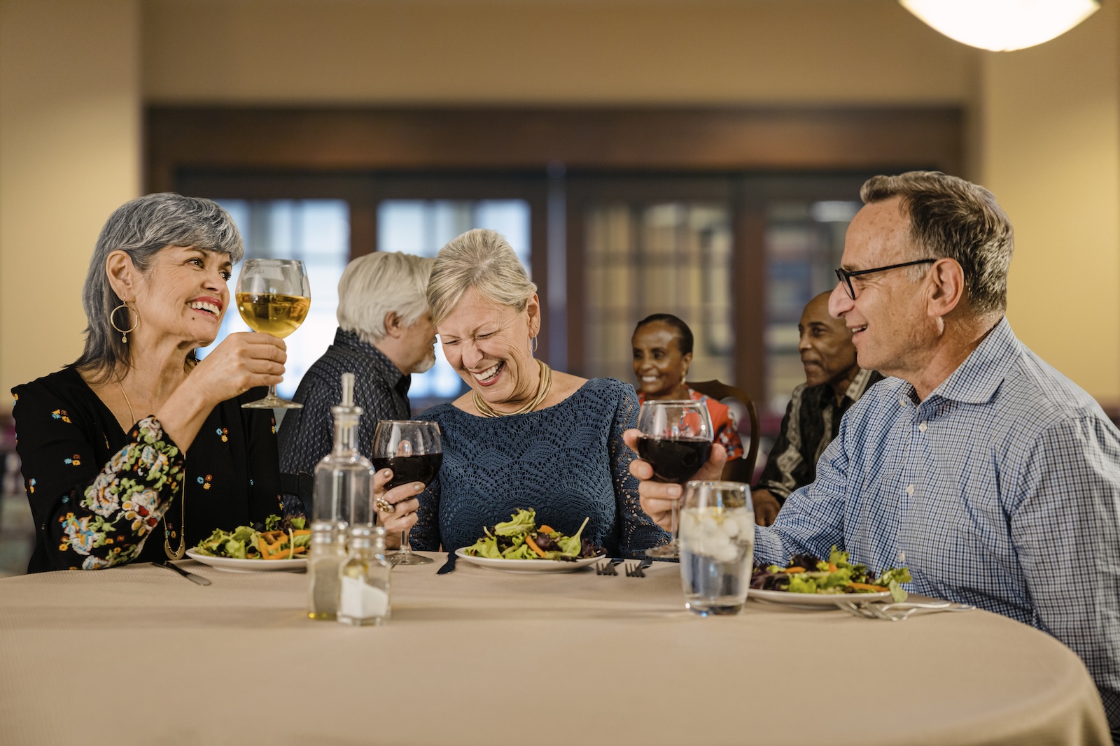 Groups of senior friends enjoying dinner in the Spring Mill Pointe dining room