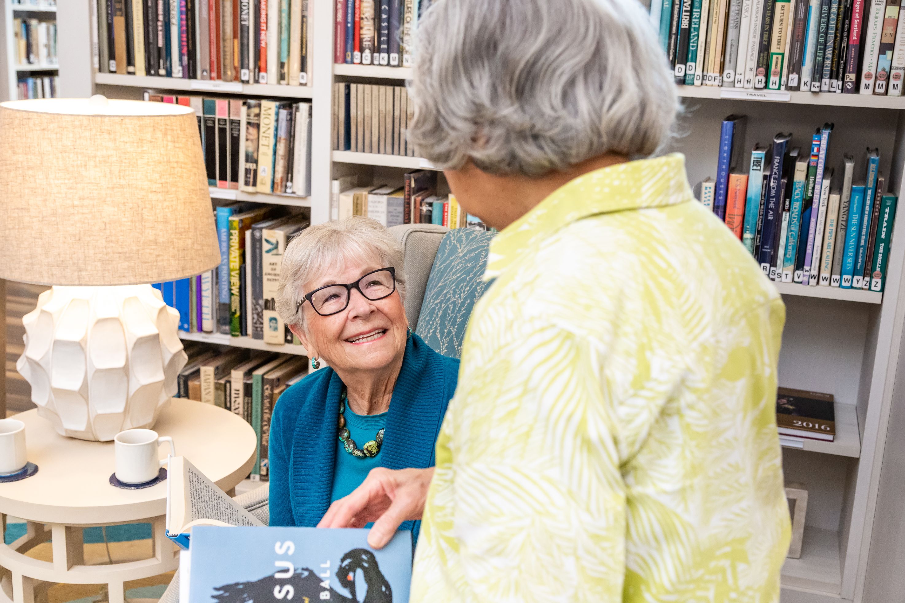Two women talking to each other in a library