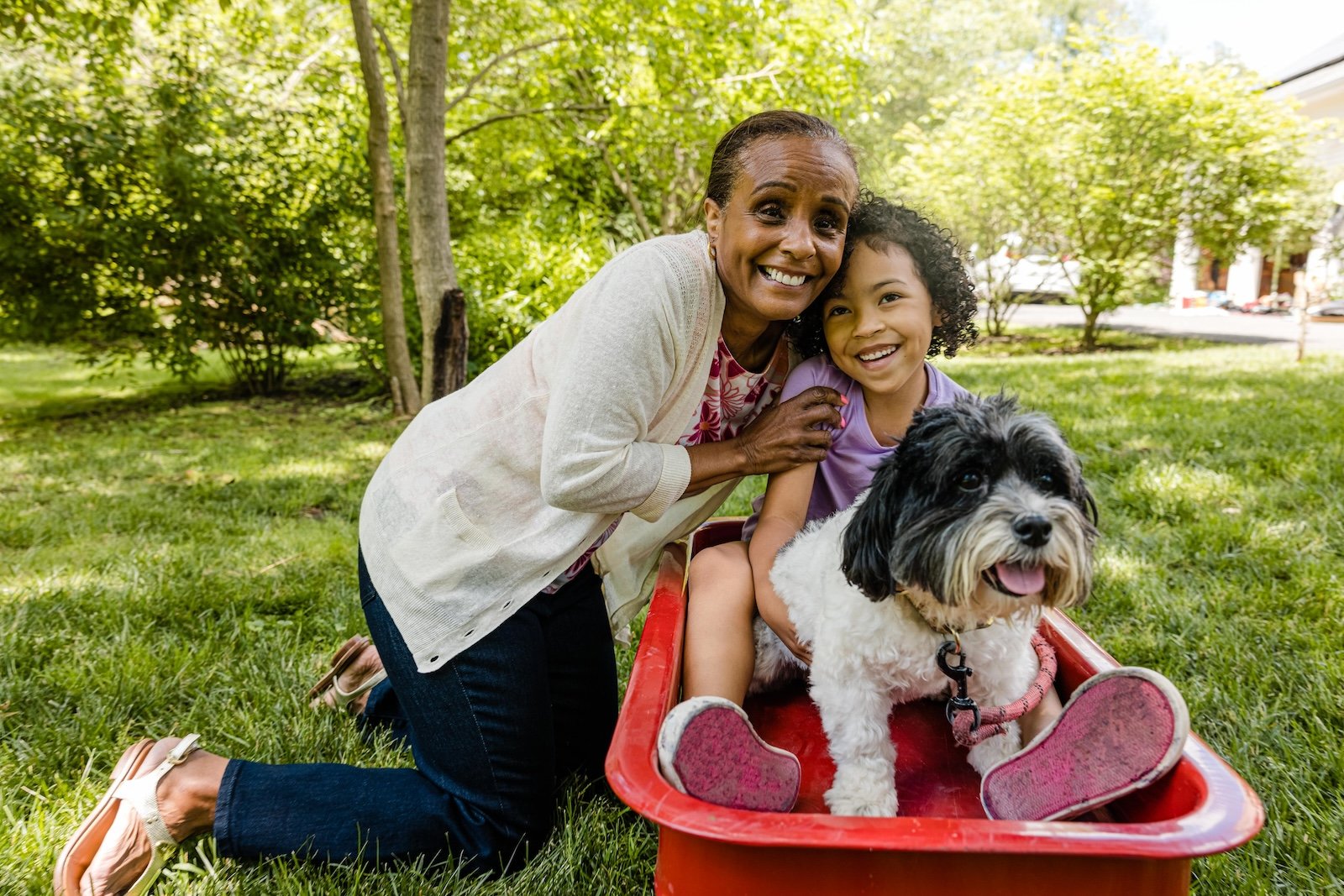 woman smiling with dog and granddaughter