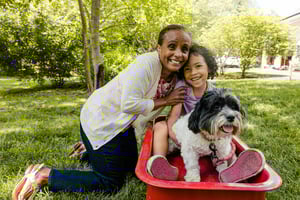 Senior woman with her granddaughter and a small black and white dog on the grounds of Spring Mill Pointe