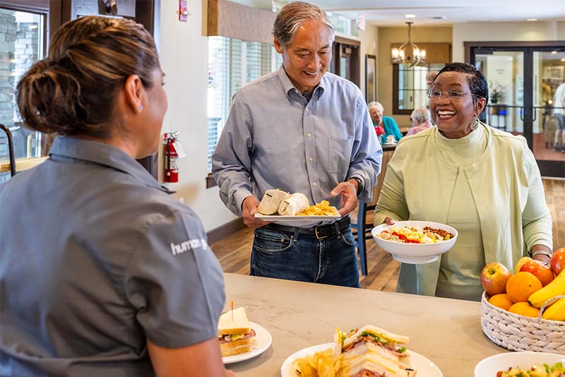 Seniors picking up meals at countertop in a cafe