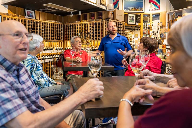 A group of senior friends tasting wine at a winery