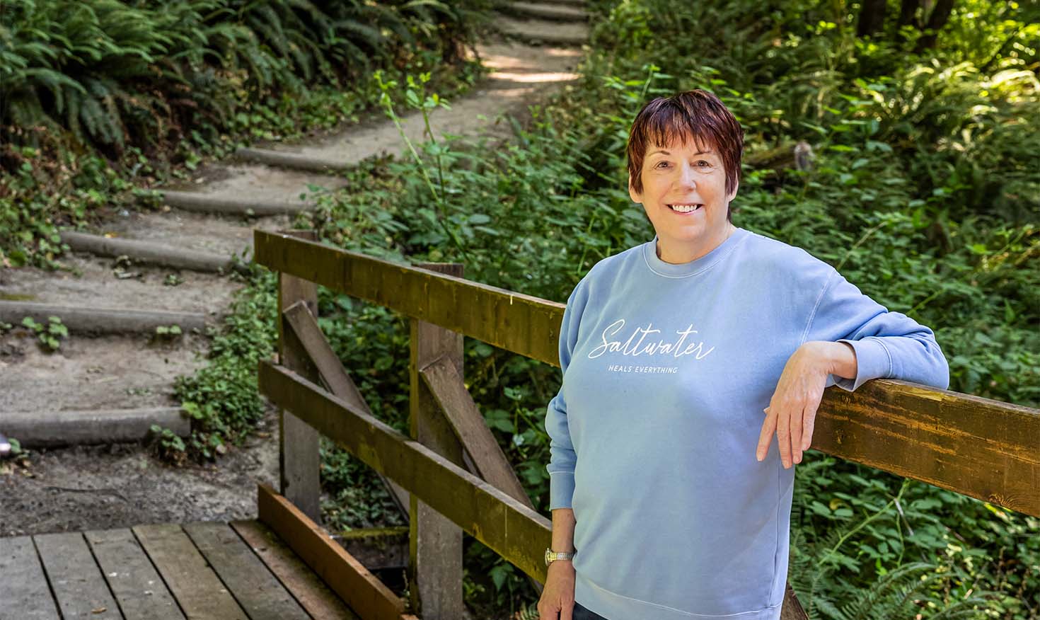 Senior woman posing on a bridge on a walking trail