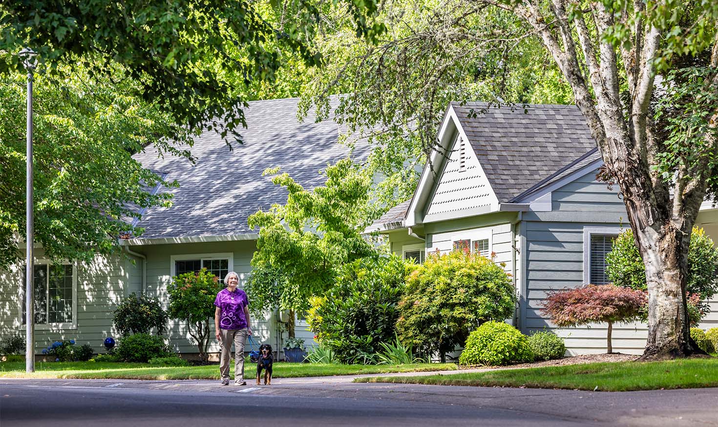 Senior woman walking her down down a quaint neighborhood street