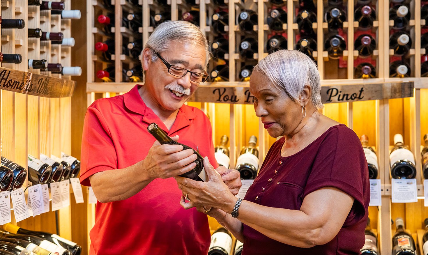 Seniors choosing a bottle of wine in a wine cellar