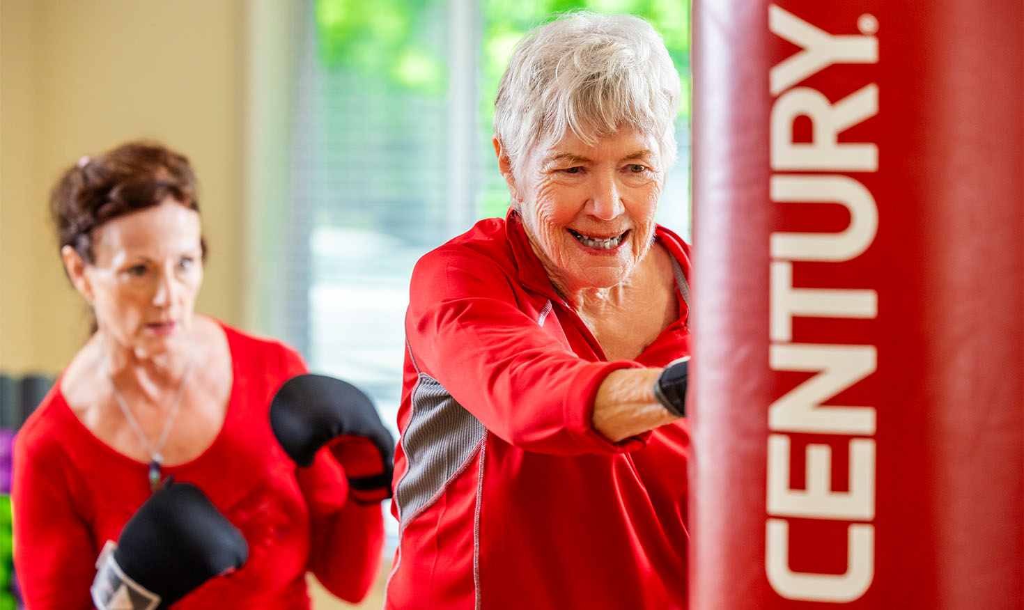 A senior woman taking a boxing fitness class