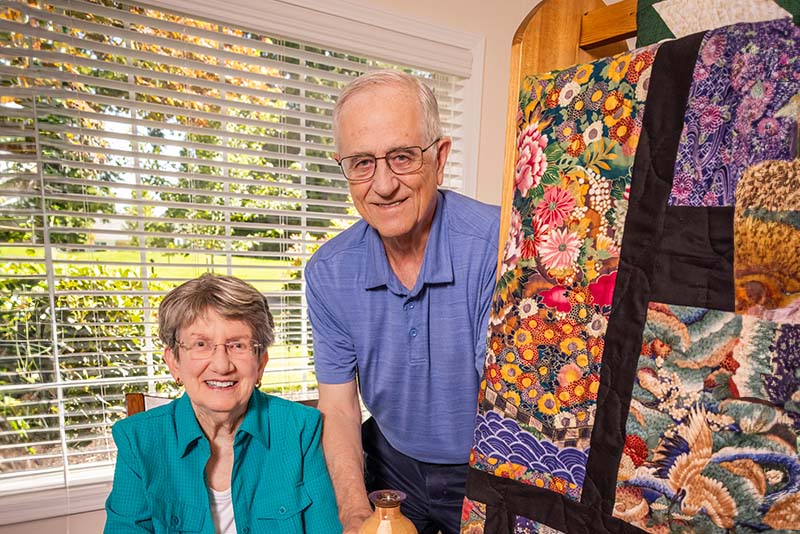 Senior couple posing next to handmade items