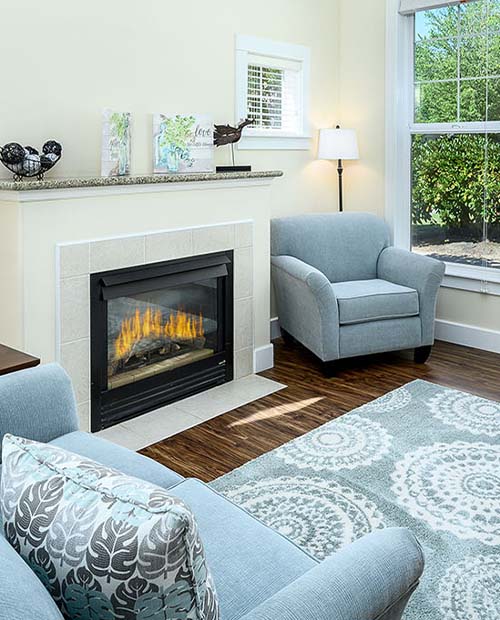 Living room of an apartment with a fireplace, living room furniture and rug
