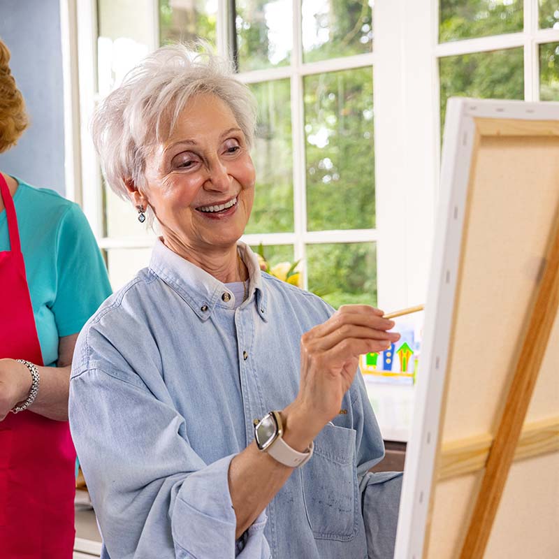 Senior woman painting on an easel