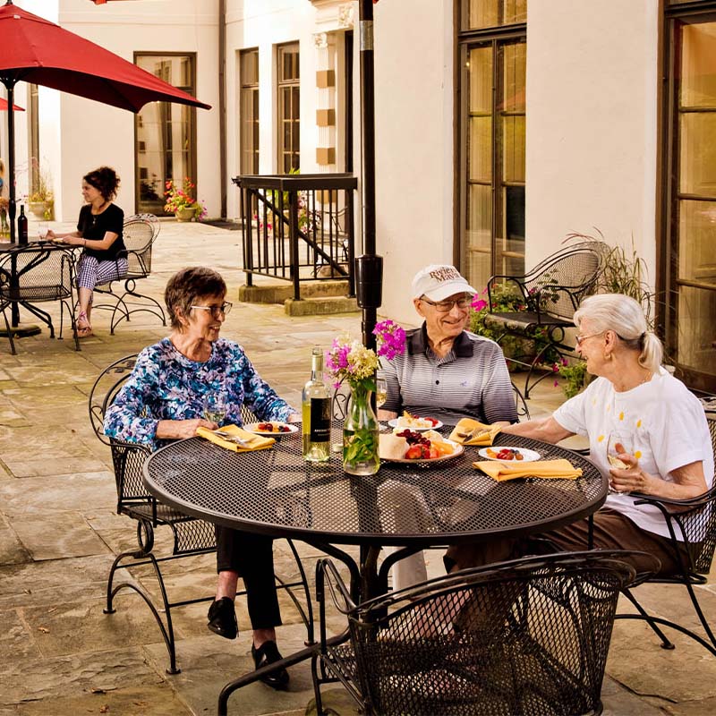 Senior friends dining on an outdoor patio
