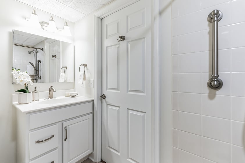 White vanity and mirror in the bathroom of a studio apartment at The Mansion at Rosemont