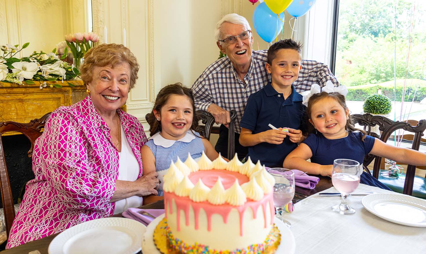 Senior grandparents celebrating a birthday with their three grandchildren