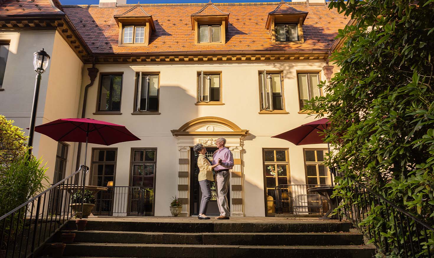 Senior couple dancing on the back patio of a mansion