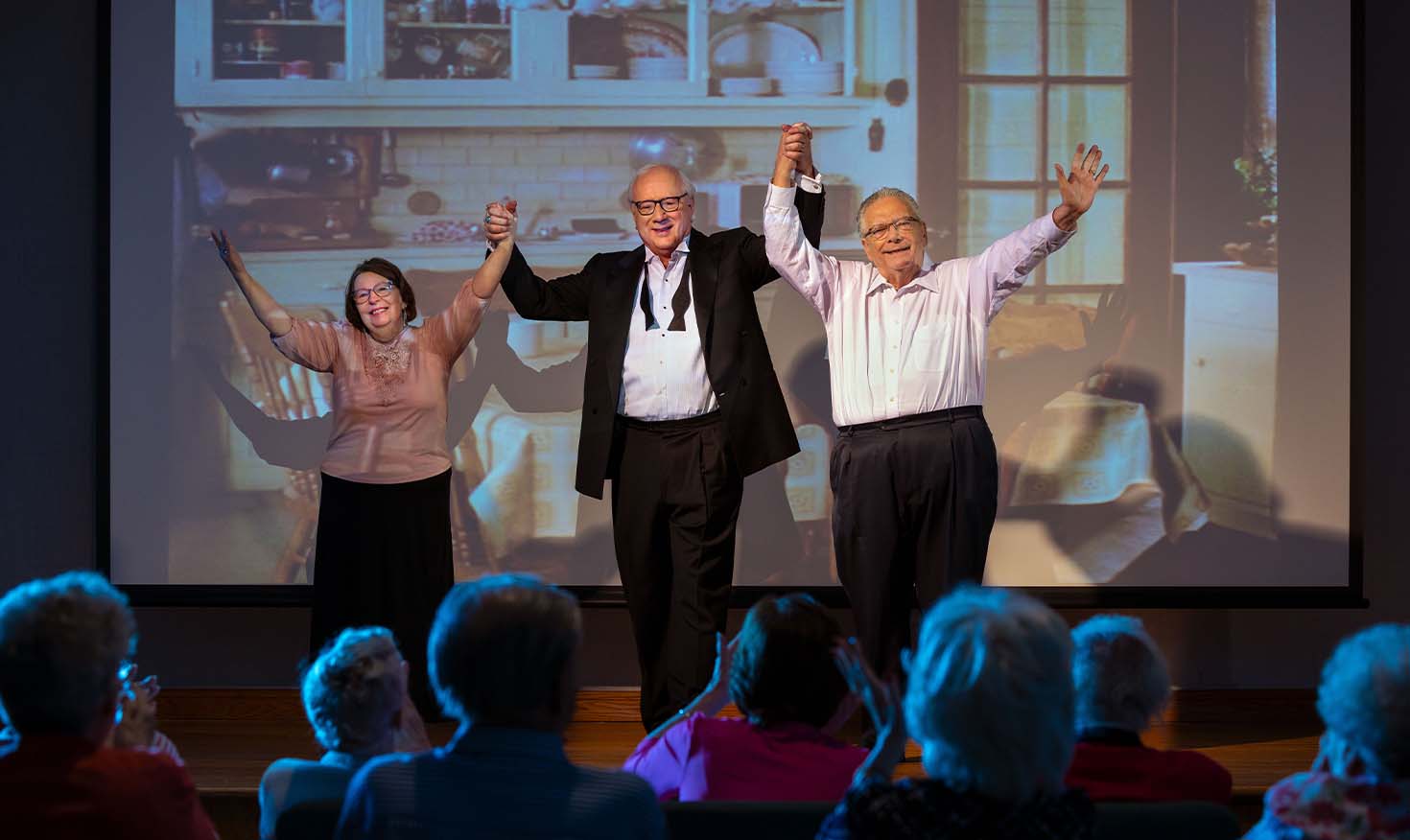 Senior actors on a stage after a performance