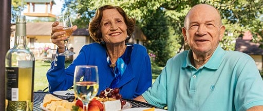 senior couple enjoying wine and cheese on outdoor patio