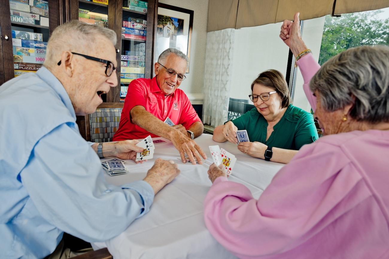 Group of senior friends playing card game
