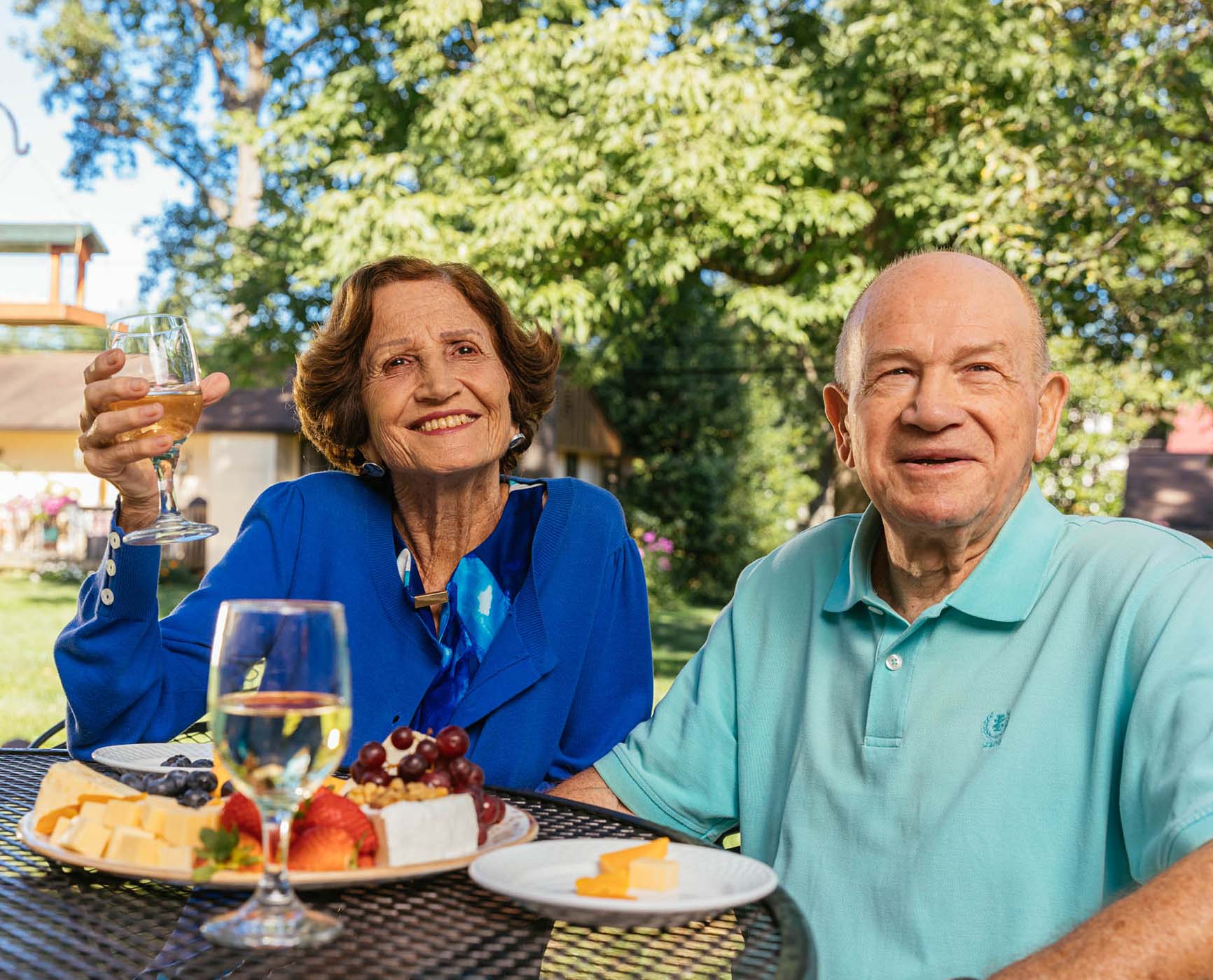 Senior couple enjoying wine and cheese on an outdoor patio