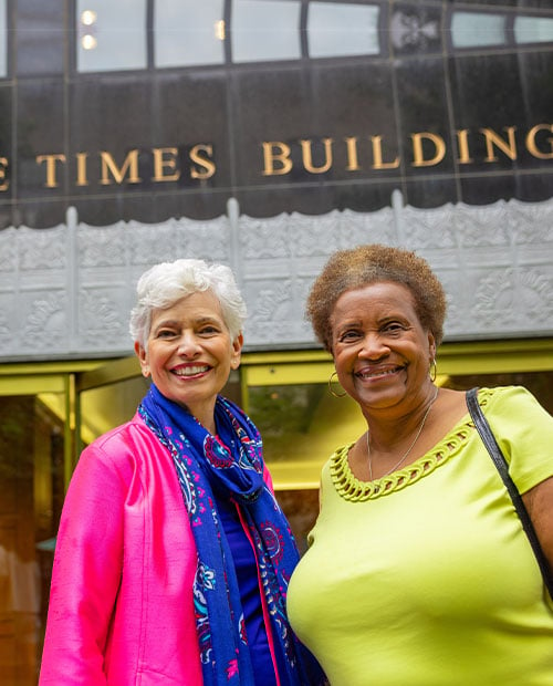 Two senior woman standing outside of The Times Building