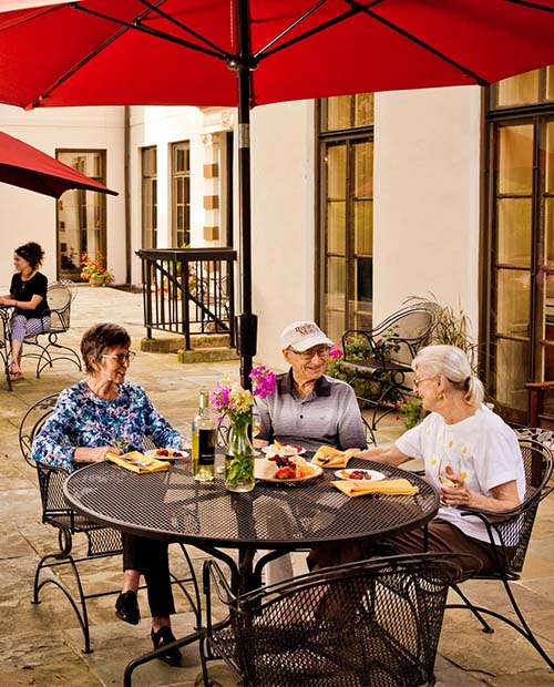Group of senior friends having lunch on an outdoor patio
