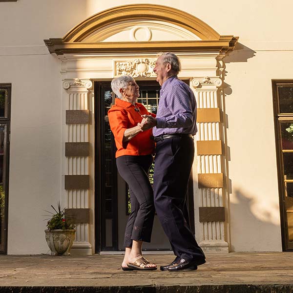 Senior couple dancing outside doorway of building