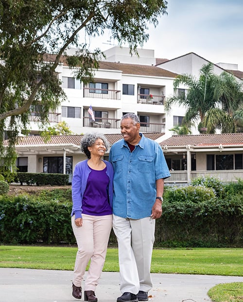 Senior couple walking through community campus