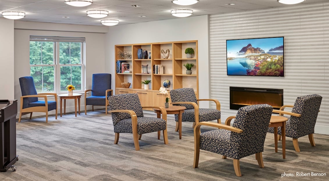 lounge with chairs, tv, and fireplace