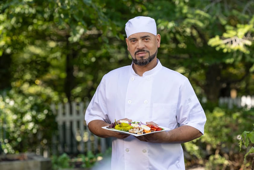 Chef holding plate of freshly prepared food