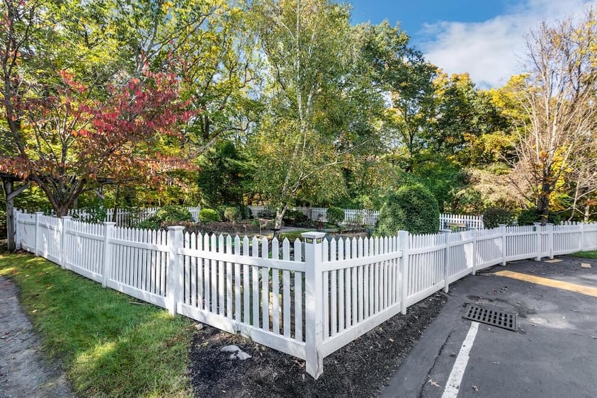 Springhouse community garden surrounded by white picket fence 