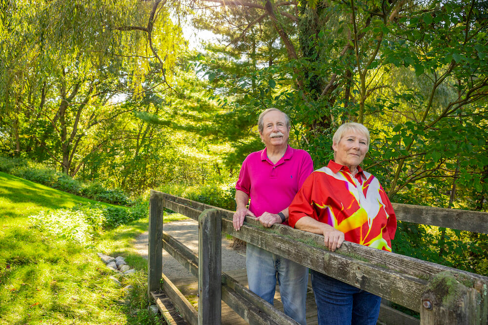 Senior couple standing on bridge on walking path