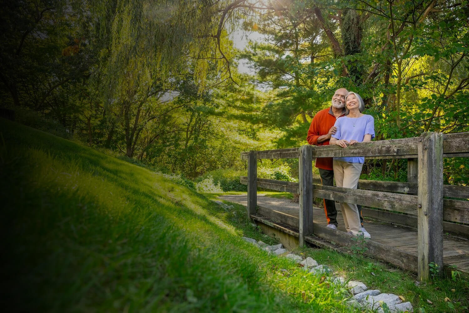 smiling senior couple on walking path bridge