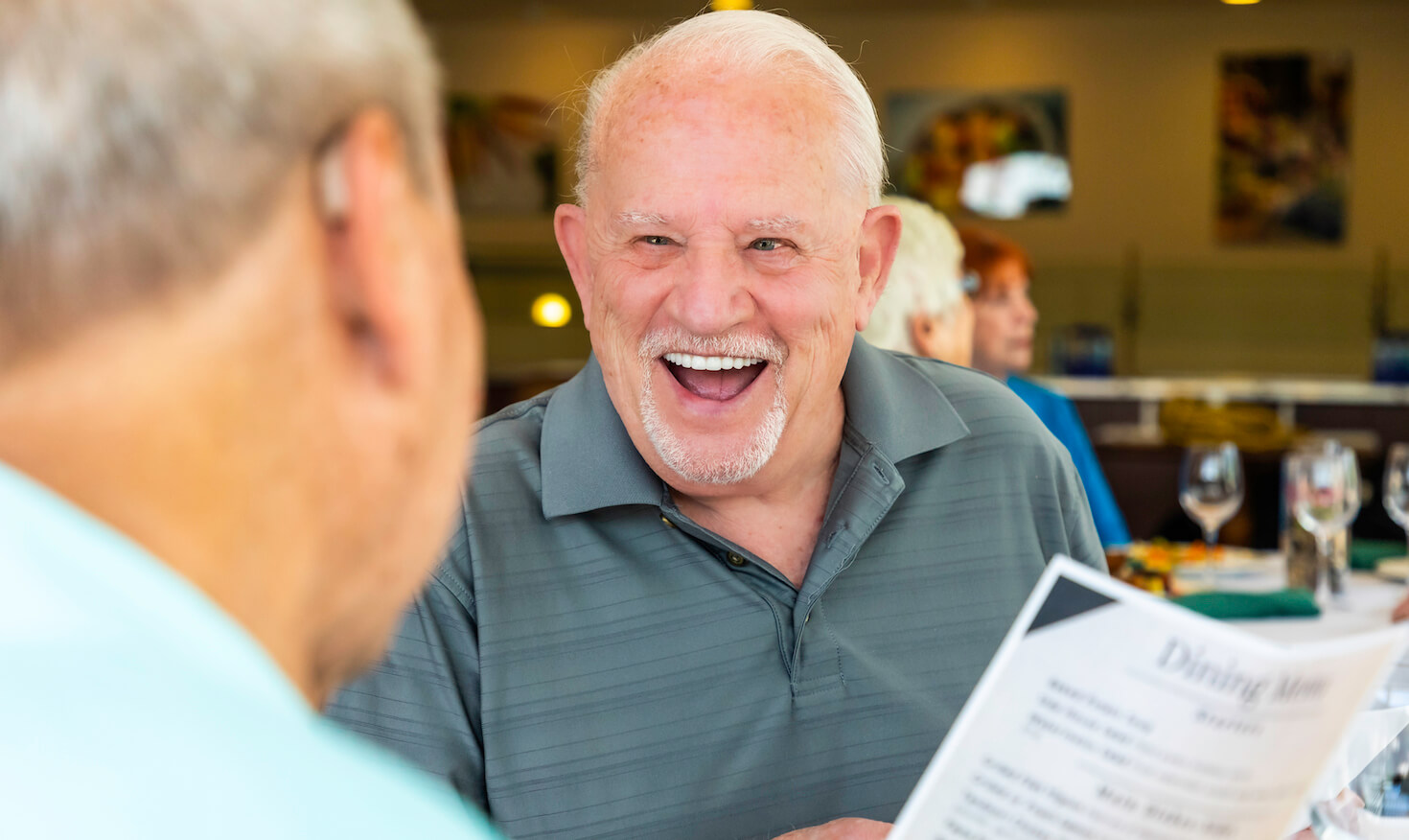 Senior man laughing with friend in the Springhouse dining room