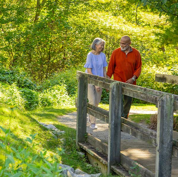 Senior couple walking outside over a small bridge