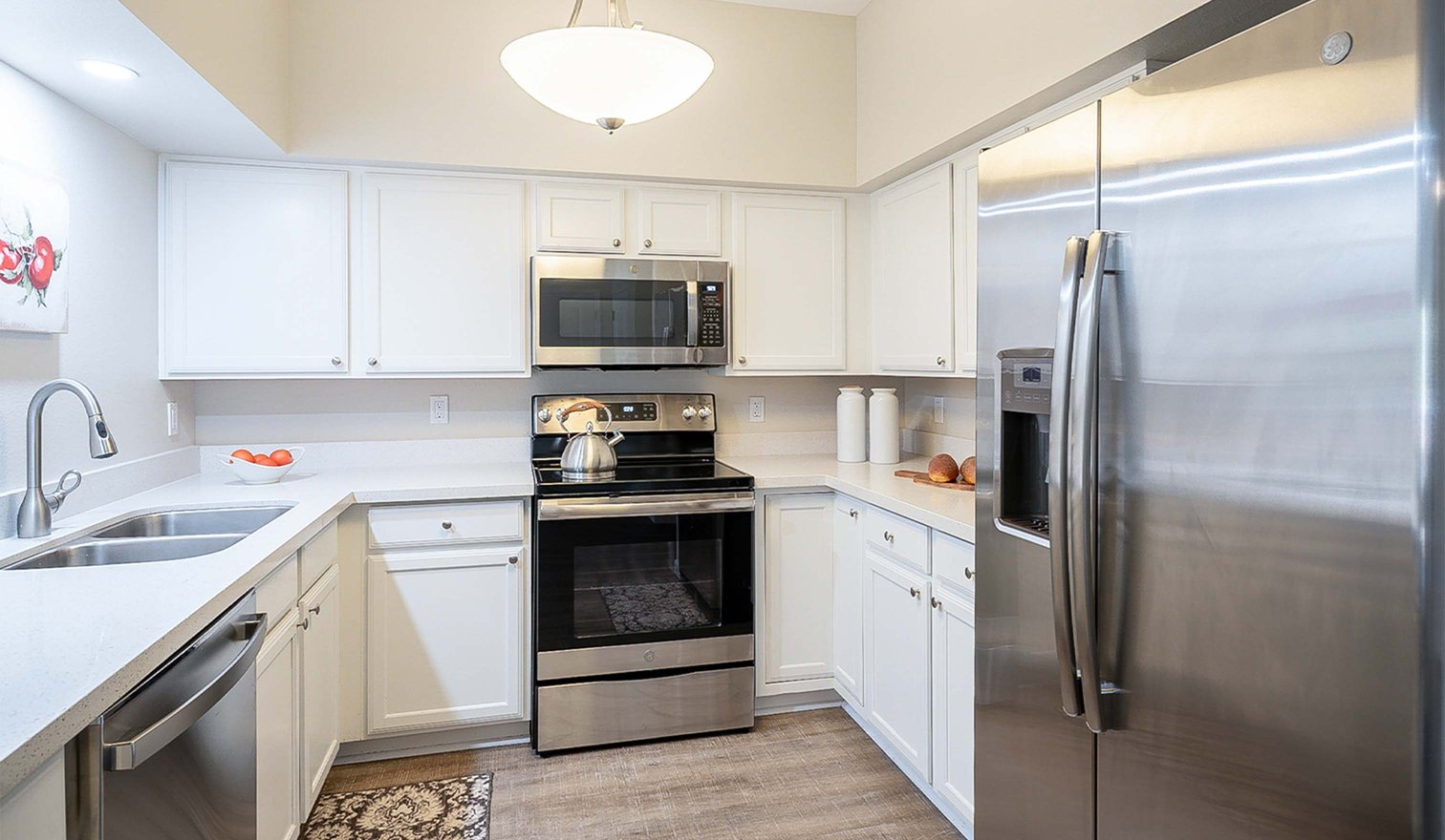 White kitchen with stainless steel appliances in an apartment at The Terraces of Phoenix