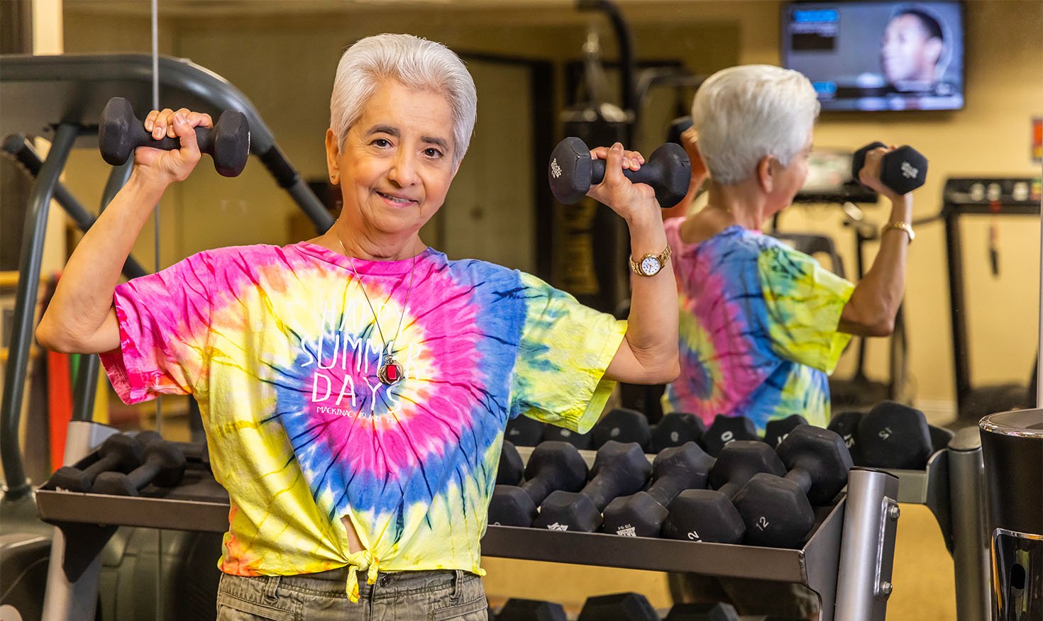 Senior woman lifting dumbbells in the fitness center