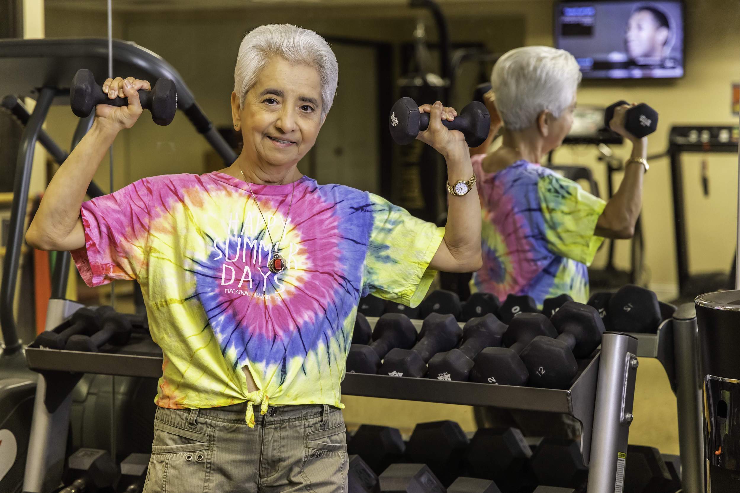 Senior woman lifting dumbbells in the fitness center
