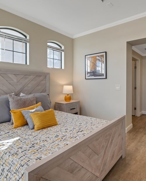 Bed and nightstand in primary bedroom of an apartment at The Terraces of Phoenix