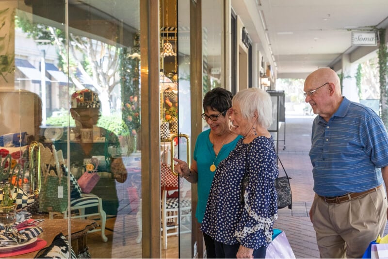 Two senior women and a senior man window shopping