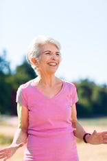 Smiling senior woman in a pink shirt outdoors