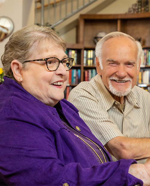 Senior man and woman smiling in a library