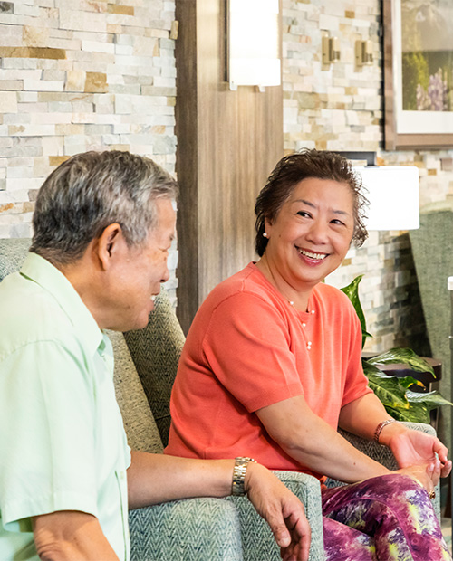 Senior man and woman sitting in armchairs