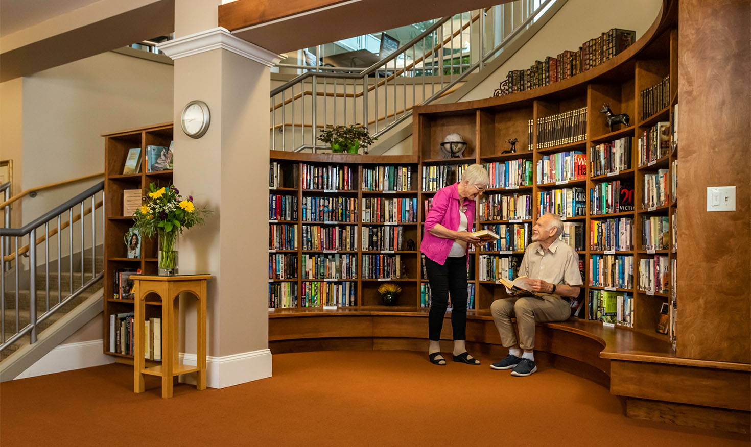Senior woman and man picking out books in the community library