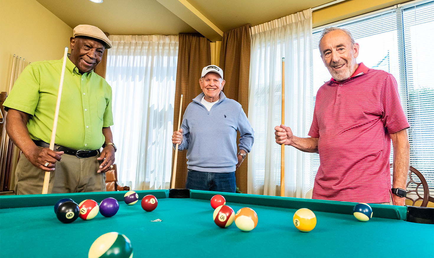 Group of three senior men playing a game of pool at Judson Park